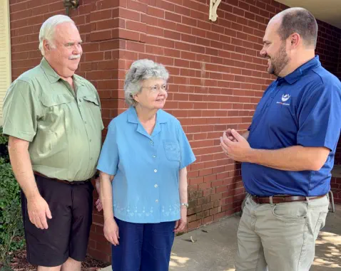 Senior Home Assurance representative speaking with clients